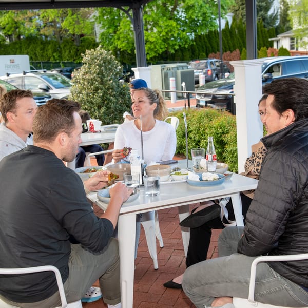 Friends enjoying Mexican food and drinks on an outdoor patio at La Taqueria.