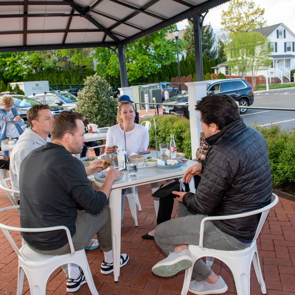 Group of people enjoying Mexican food and drinks at an outdoor patio table at La Taqueria.