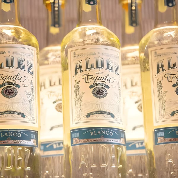 Several bottles of Aldez Blanco Tequila with detailed labels are displayed in a row.