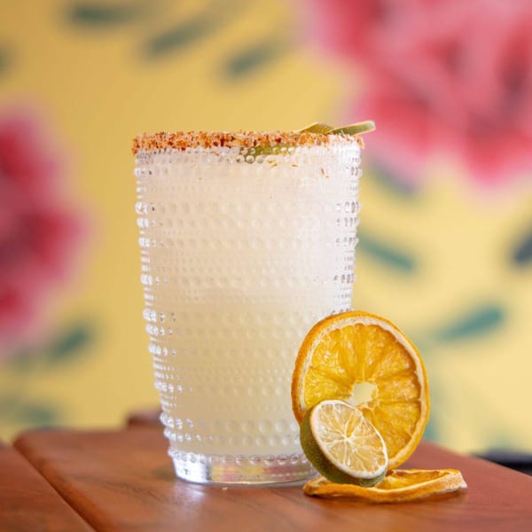 La Taqueria's margarita in a textured glass, garnished with dried orange and lime slices.